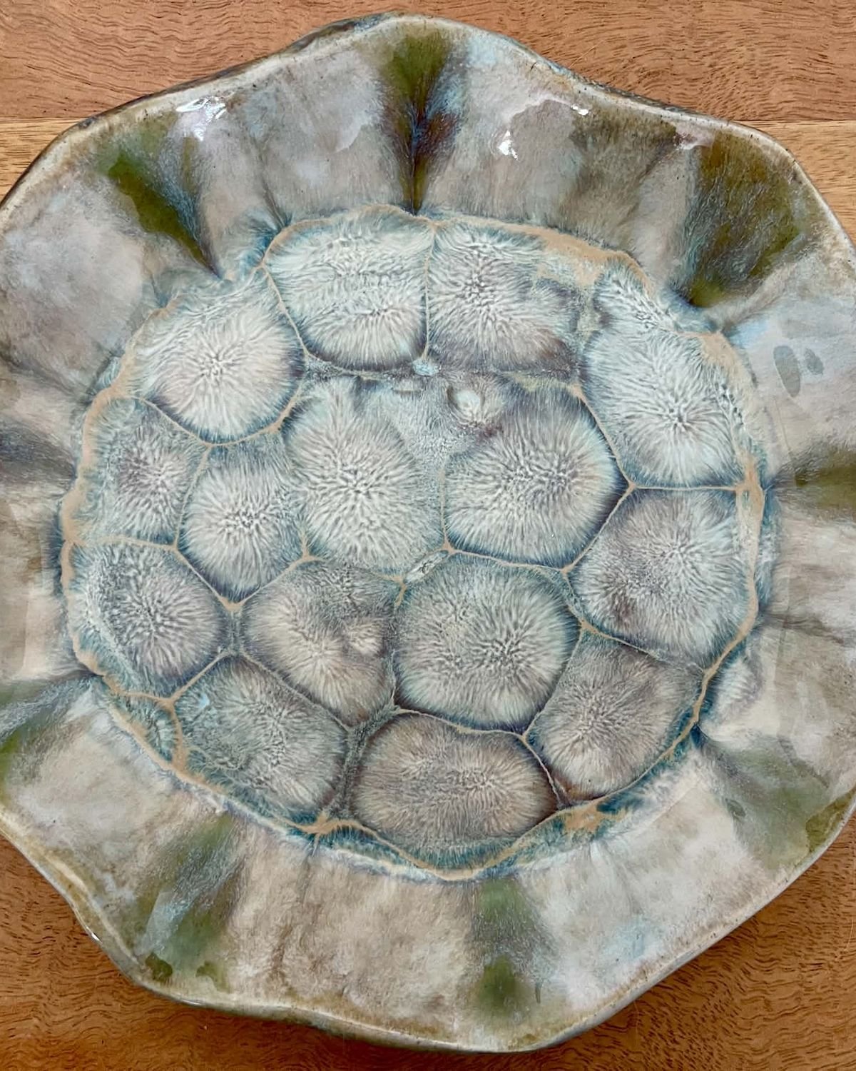 Wide ruffled plate with a turtle-shell pattern in pale green and grey glazes